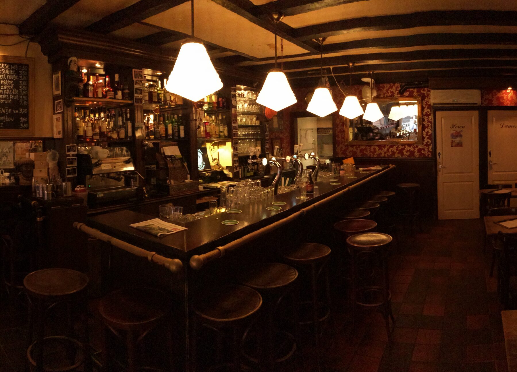 De bar met barkrukken en witte hanglampen